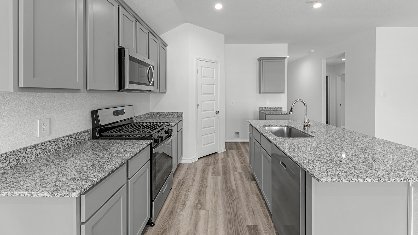 Harris kitchen with granite counters and grey cabinets.