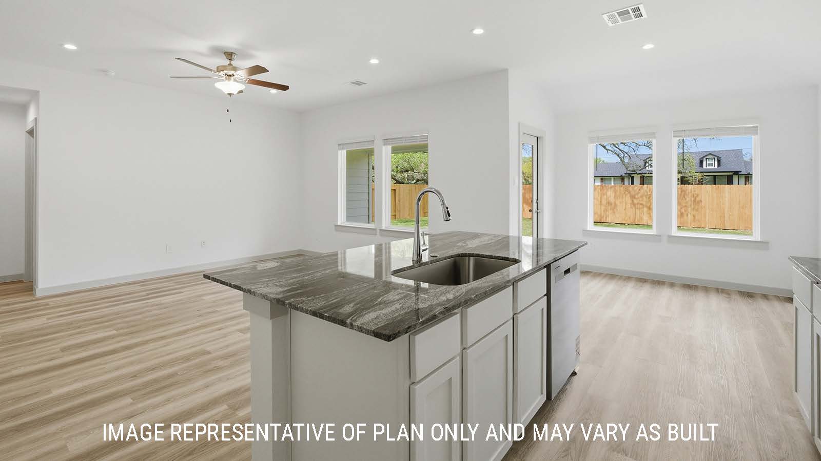 Bellvue kitchen with kitchen island with dark granite countertops and view of open concept dining room and living room.