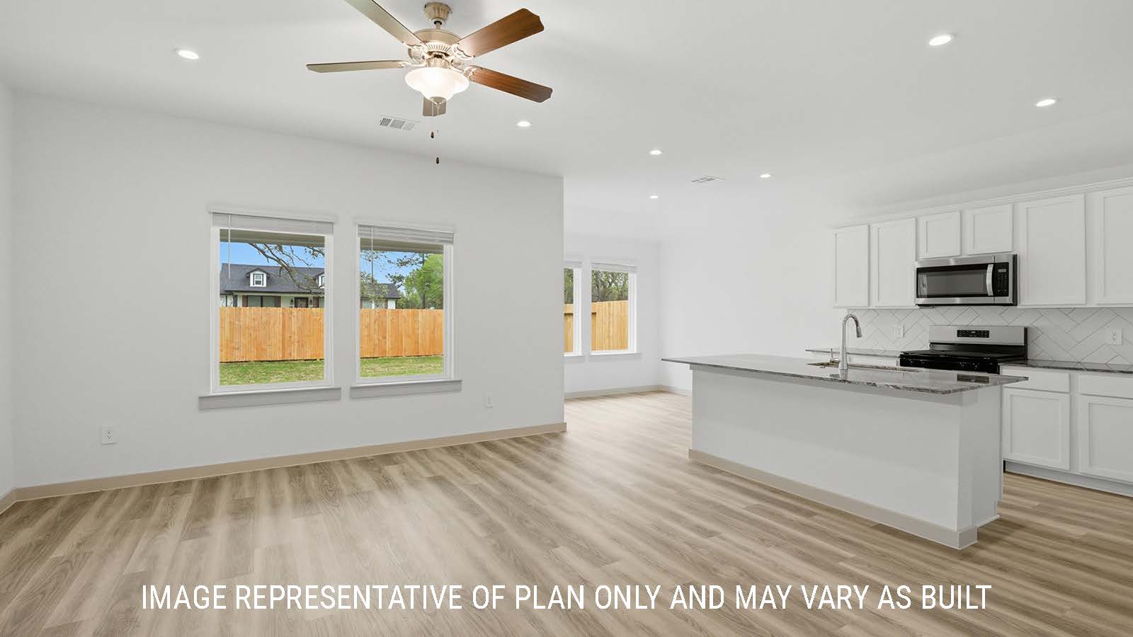 Bellvue living room with vinyl plank flooring and view of open concept kitchen and dining room.