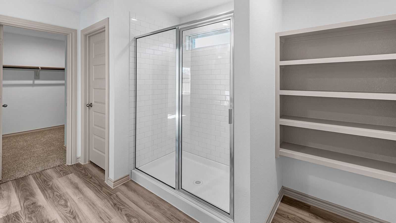 Camden primary bathroom with walk-in shower and view of walk-in closet.