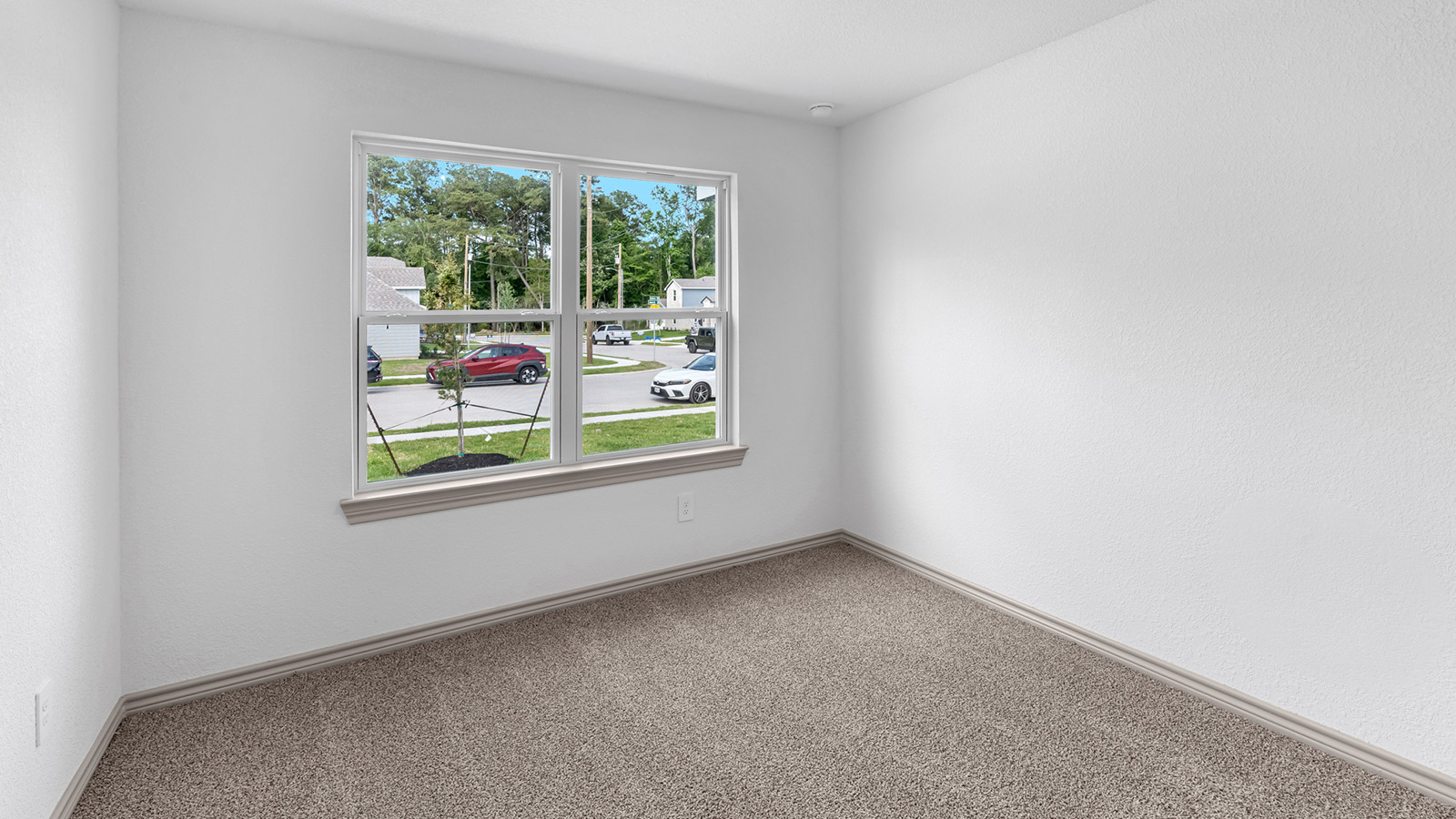 Camden secondary bedroom with carpet flooring and view of living room.