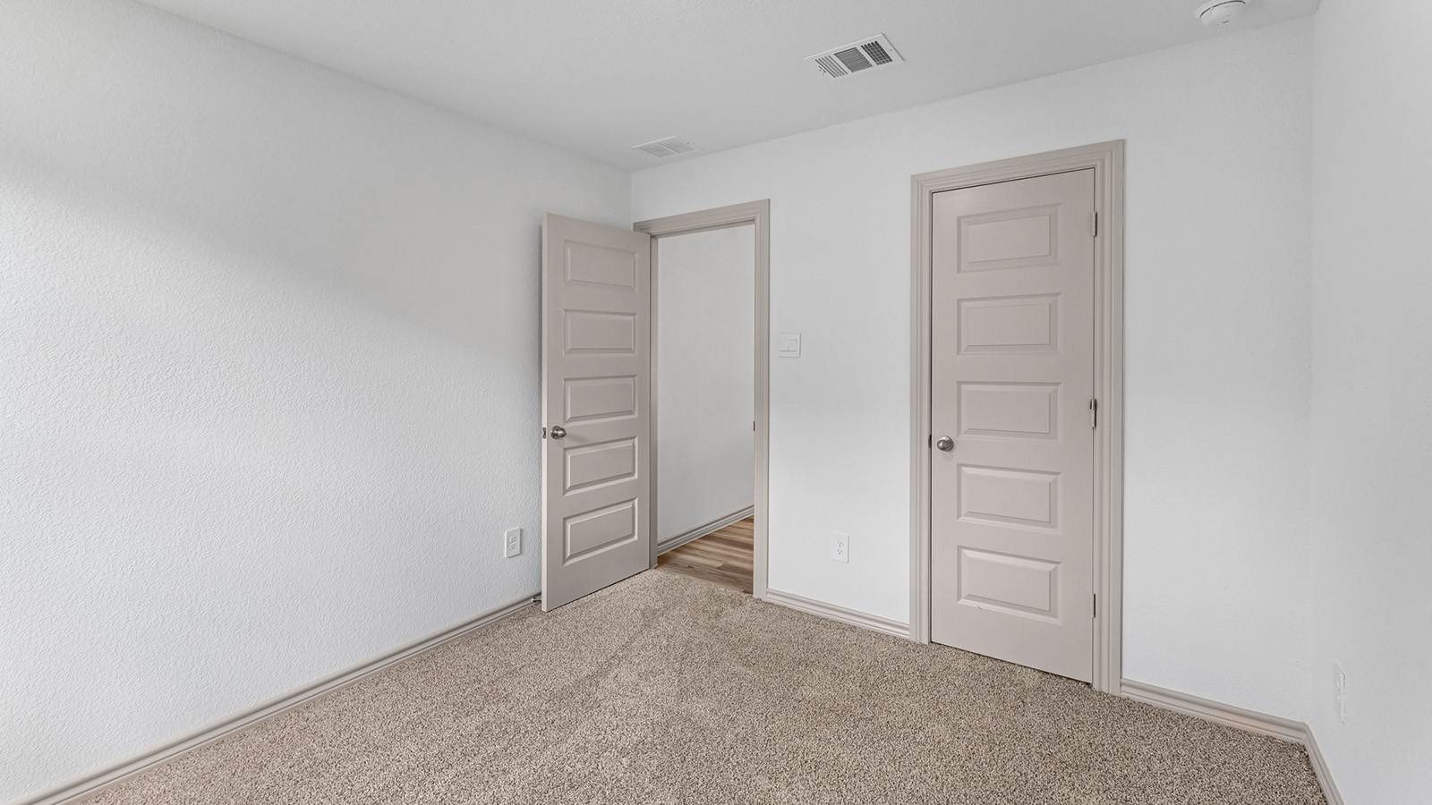 Camden secondary bedroom with carpet flooring and window with outside view.