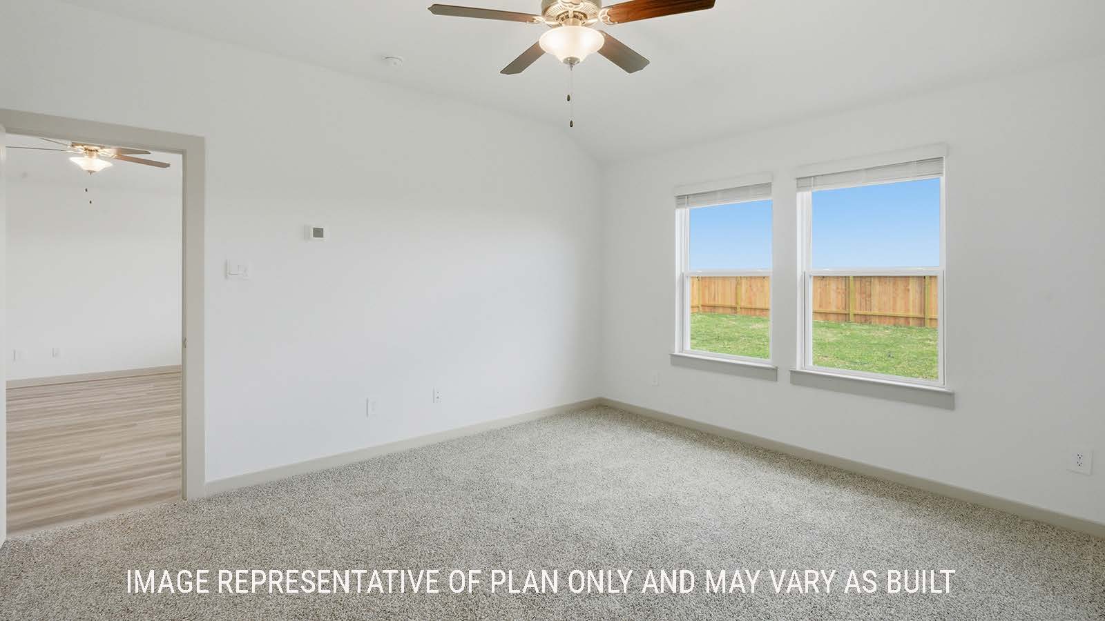 Elgin primary bedroom with carpeted flooring and windows for natural lighting.