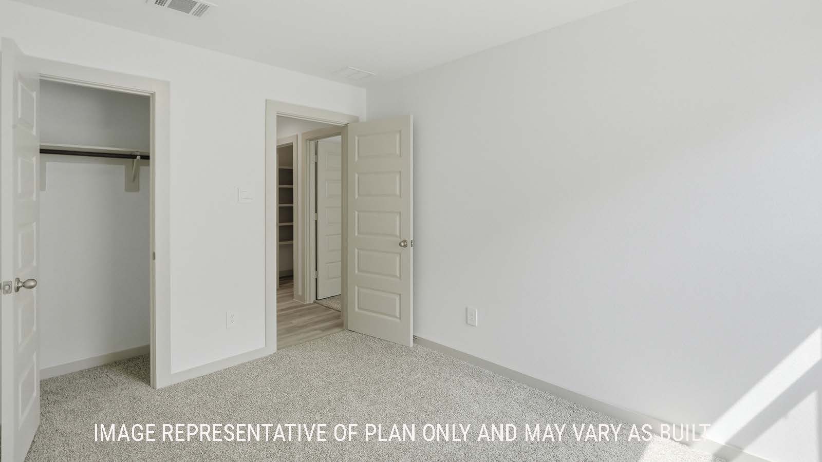 Elgin secondary bedroom with carpeted flooring and view of hallway to kitchen.
