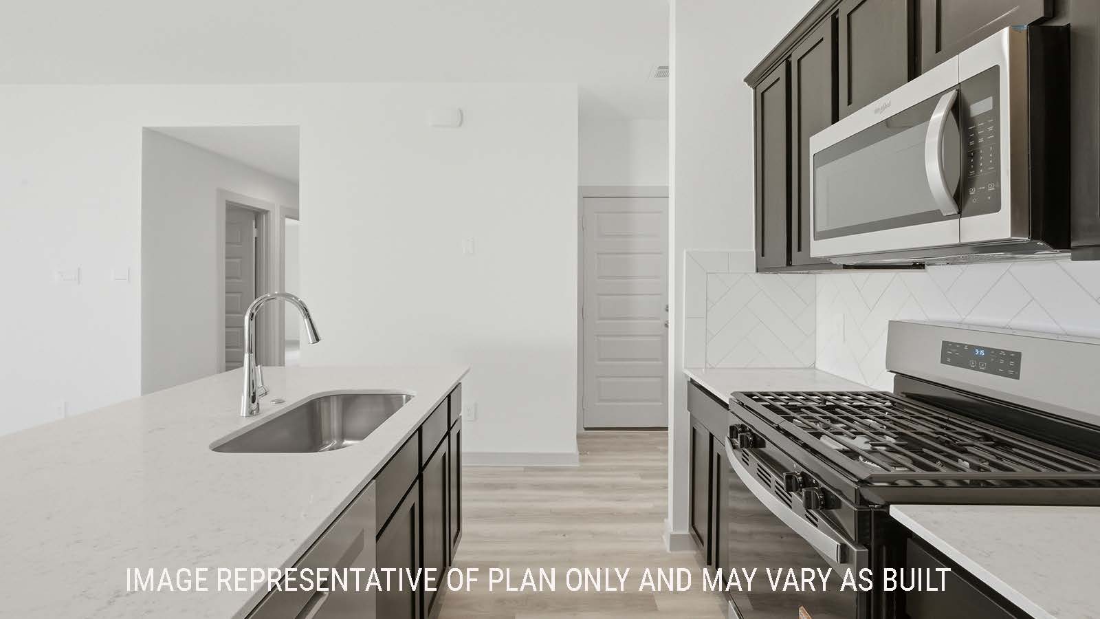 Elgin kitchen with kitchen island with granite countertops and dark cabinets with view of secondary bedrooms.