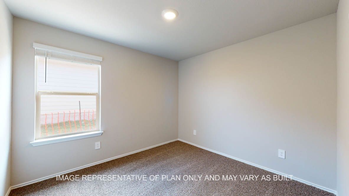 Fargo secondary bedroom with carpet flooring and window.