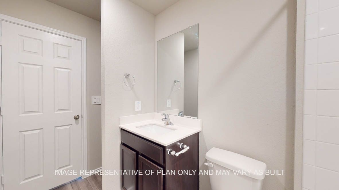 Fargo secondary bath with dark cabinets and white countertops.