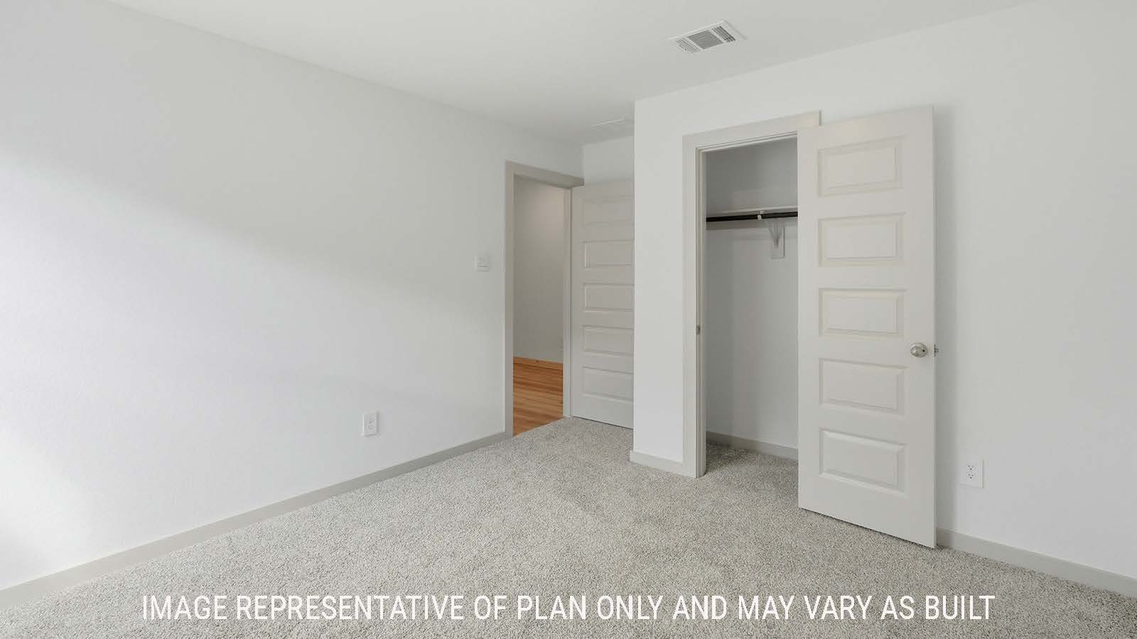 Texas Cali secondary bedroom with carpeted flooring and view of front hallway.