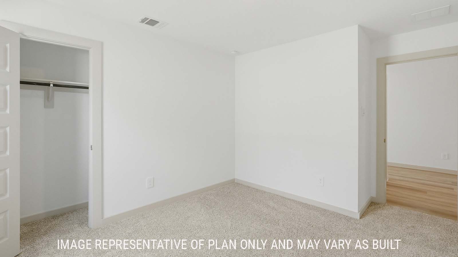 Texas Cali secondary bedroom with carpeted flooring and view of front hallway.