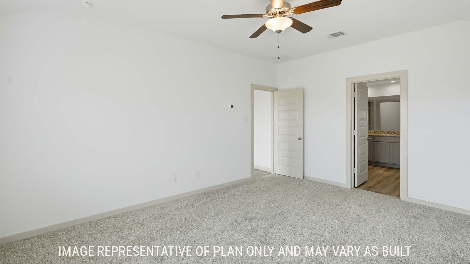 Texas Cali primary bedroom with carpeted flooring with view of primary bathroom.