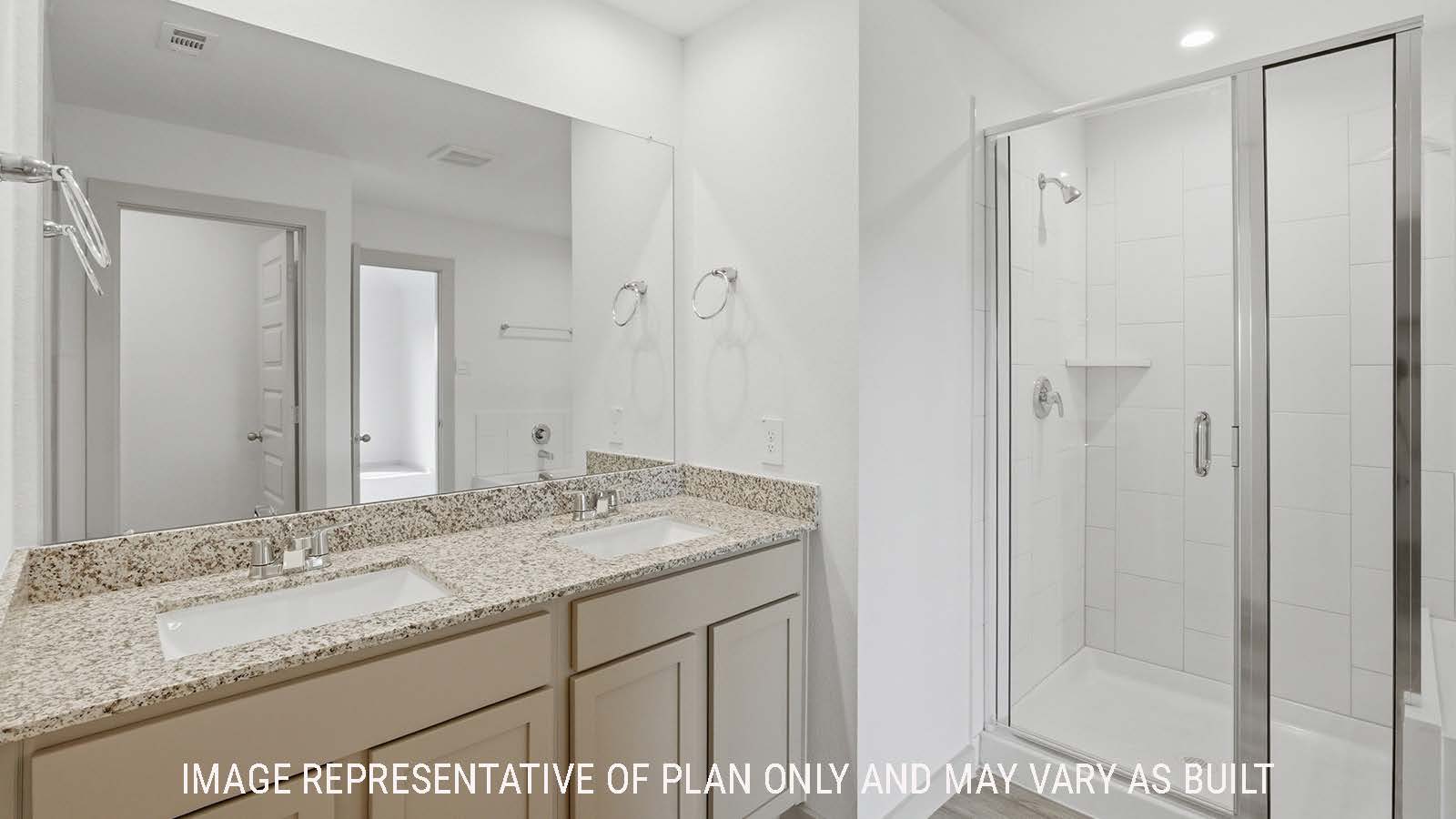 Texas Cali primary bathroom with double vanity sink with granite countertops and walk-in shower.