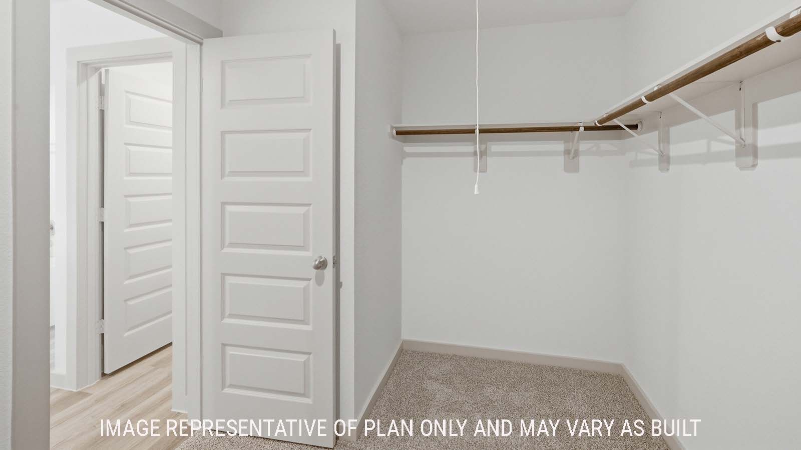 Texas Cali primary bedroom closet with carpeted flooring and shelving for storage.