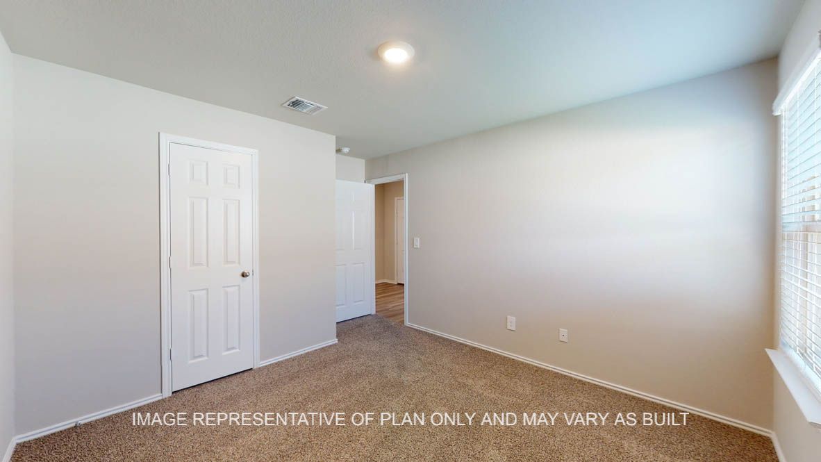 Kingston secondary bedroom with carpet flooring and closet door.