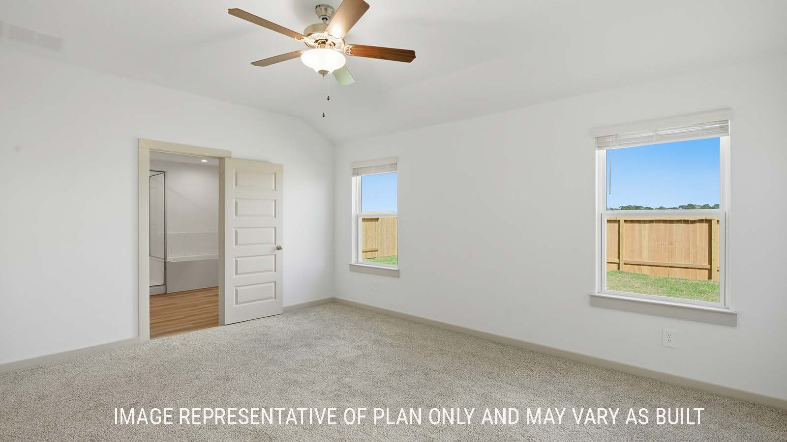 Lakeway primary bedroom with carpeted flooring and view of primary bathroom.