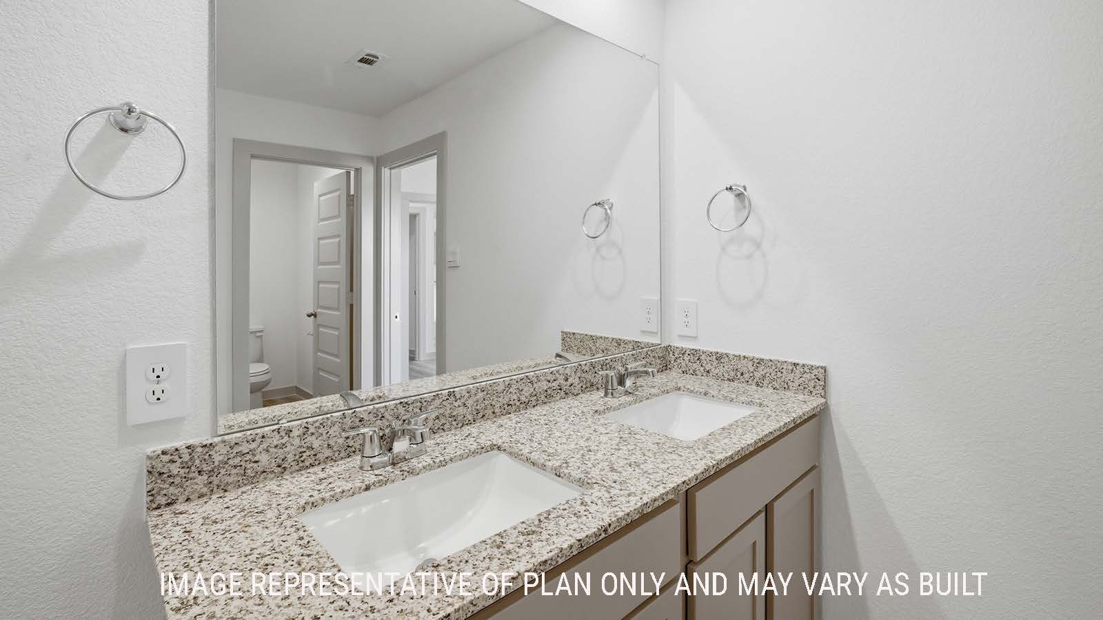 Lakeway primary bathroom with duel vanity sink with granite countertops and mirror.