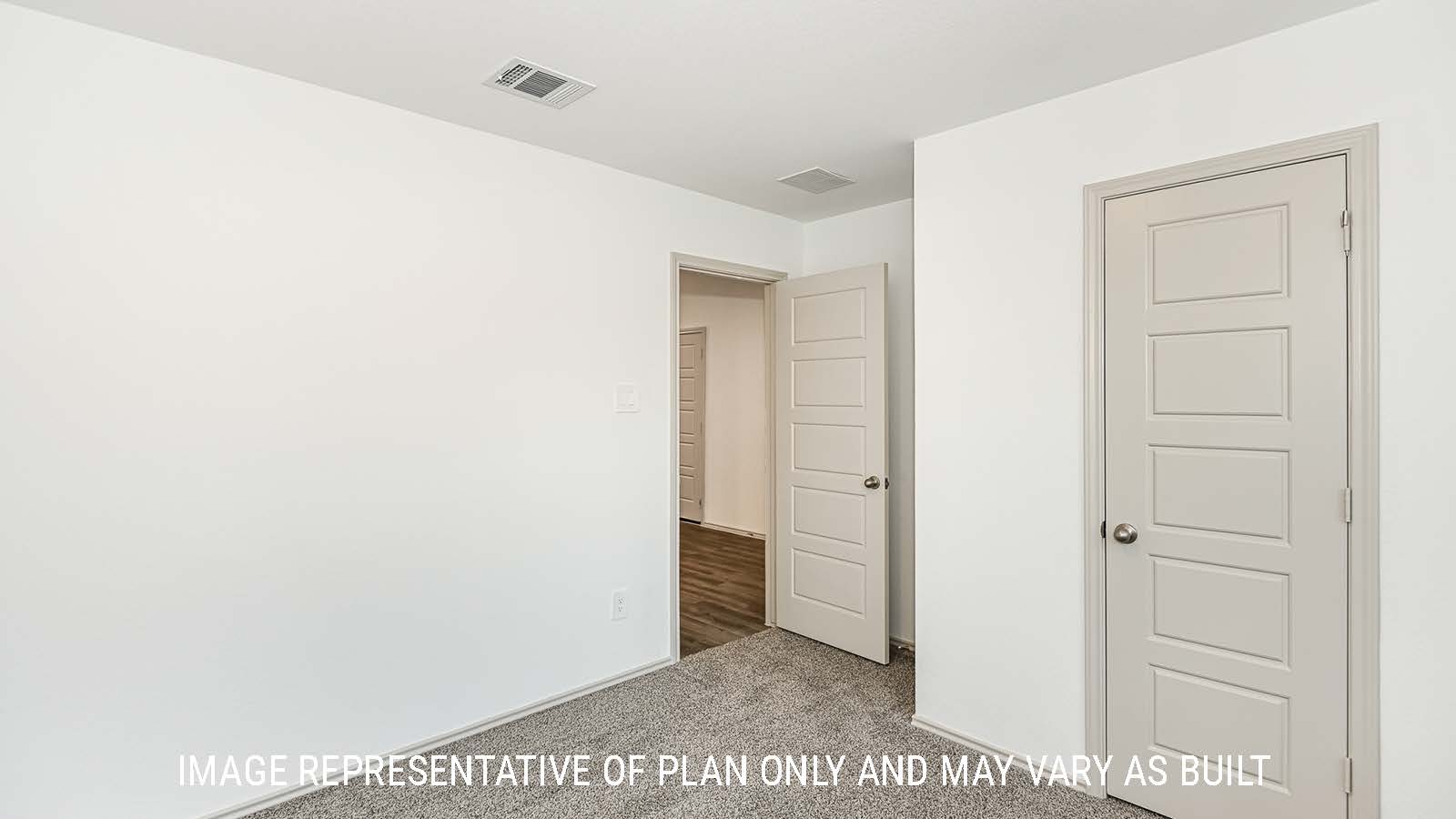 Lakeway secondary bedroom with carpeted flooring and view of living room.