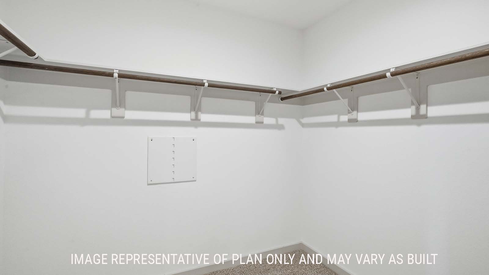 Lakeway primary bedroom walk-in closet with carpeted flooring and shelving for storage.