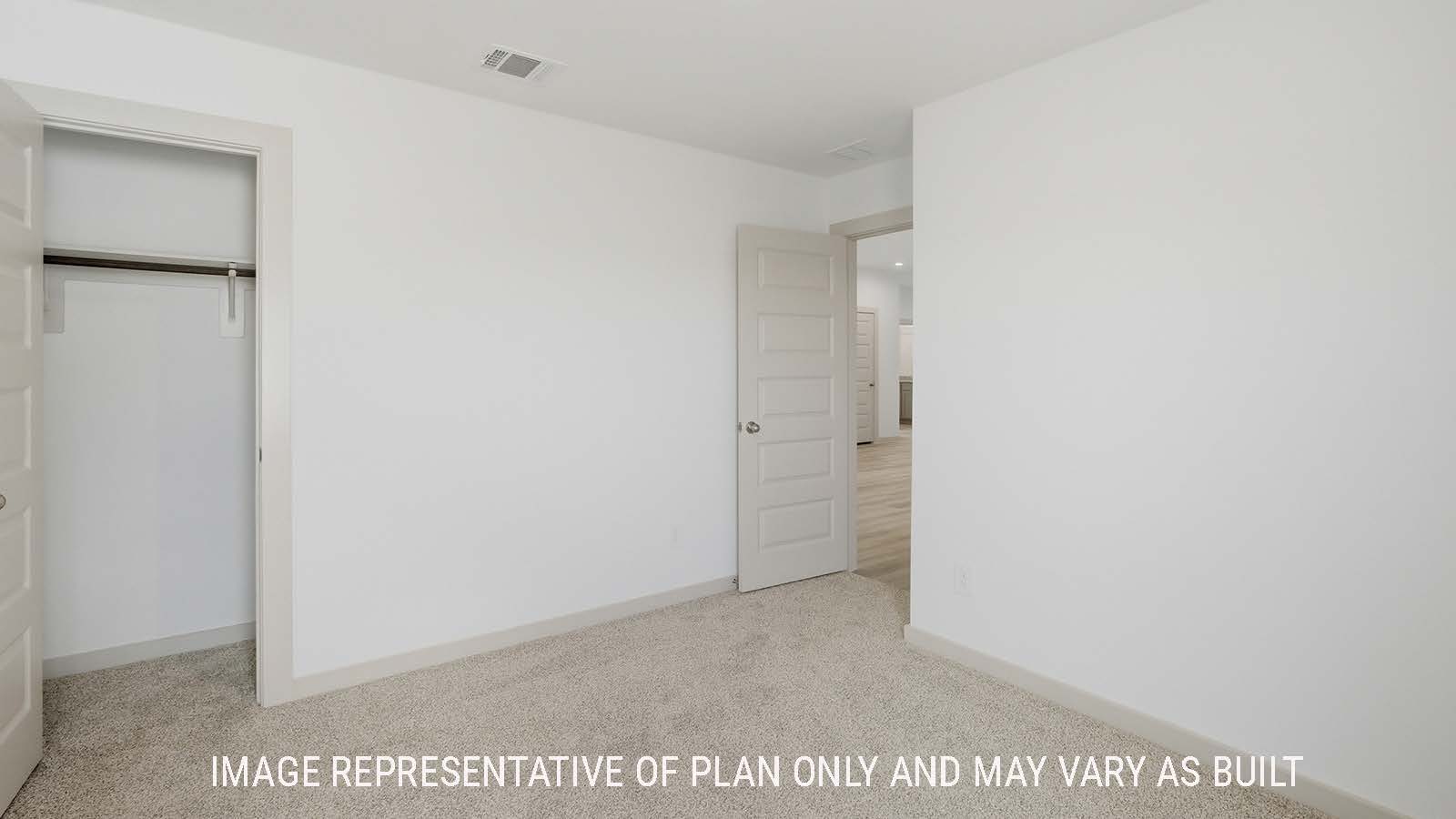 Lakeway secondary bedroom with carpeted flooring with view of open concept dining room.