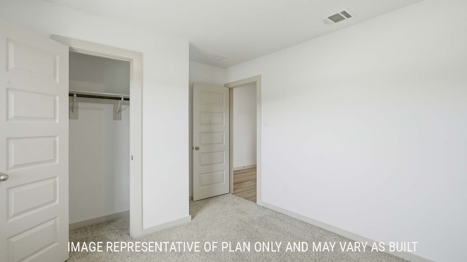 Lakeway secondary bedroom with carpeted flooring with view of open concept dining room.