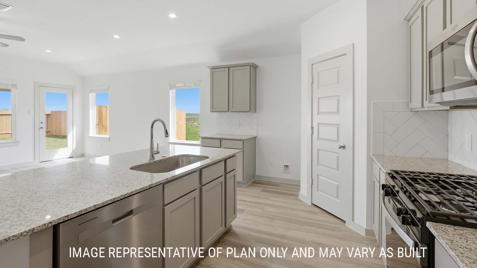 Lakeway kitchen with granite countertops and light cabinets with view of open concept living room.