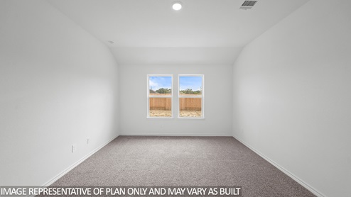 Baxtor primary bedroom with carpet flooring and view to backyard.