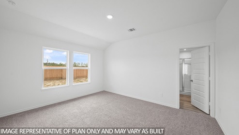 Baxtor primary bedroom with carpet flooring and view to backyard.