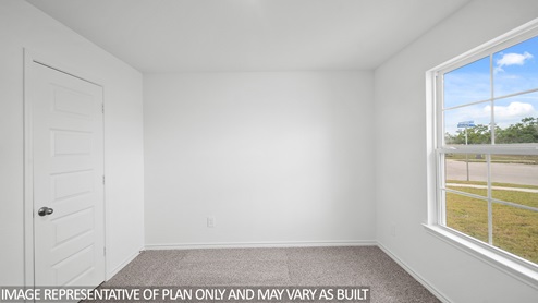 Baxtor secondary bedroom with carpet flooring and window.