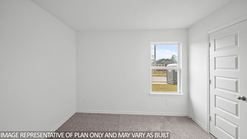 Baxtor secondary bedroom with carpet flooring and window.