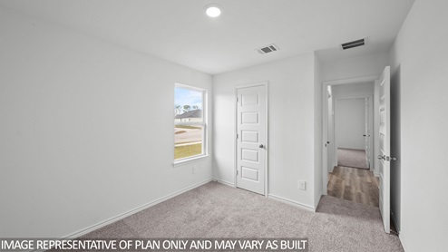 Baxtor secondary bedroom with carpet flooring and window.