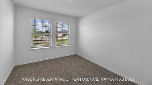 Denton secondary bedroom with carpet flooring and windows.