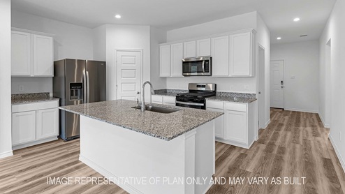 Denton kitchen island with light cabinets and granite countertops.
