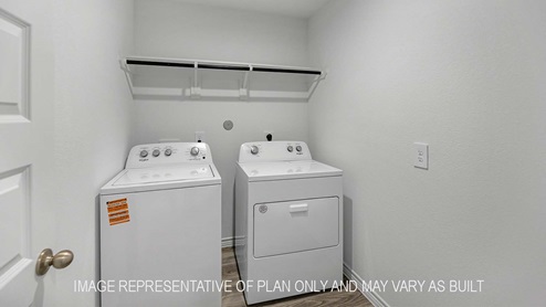 Denton utilty room with washer and dryer and storage shelving.