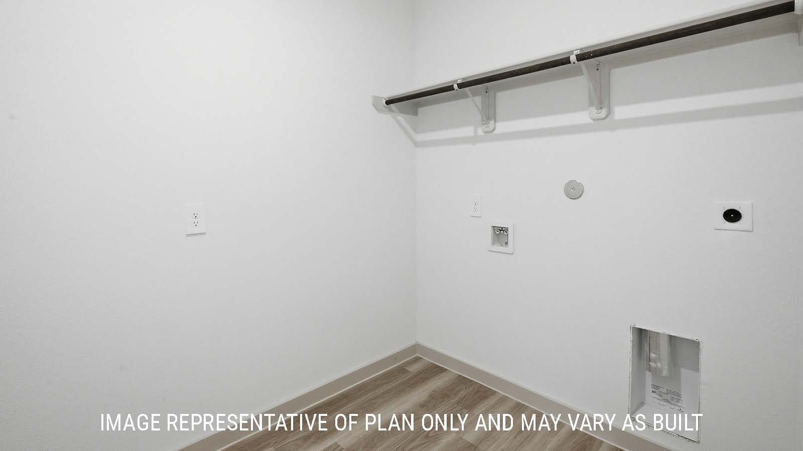 Mitchell utility room with washer and dryer connections with shelving for storage.