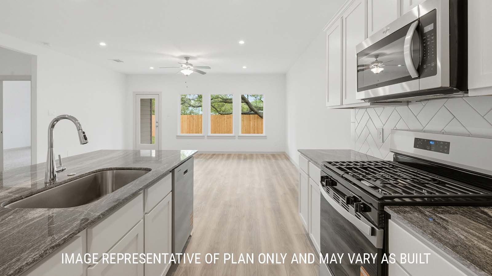Mitchell kitchen with light cabinets and dark granite countertops with view of open concept living room.