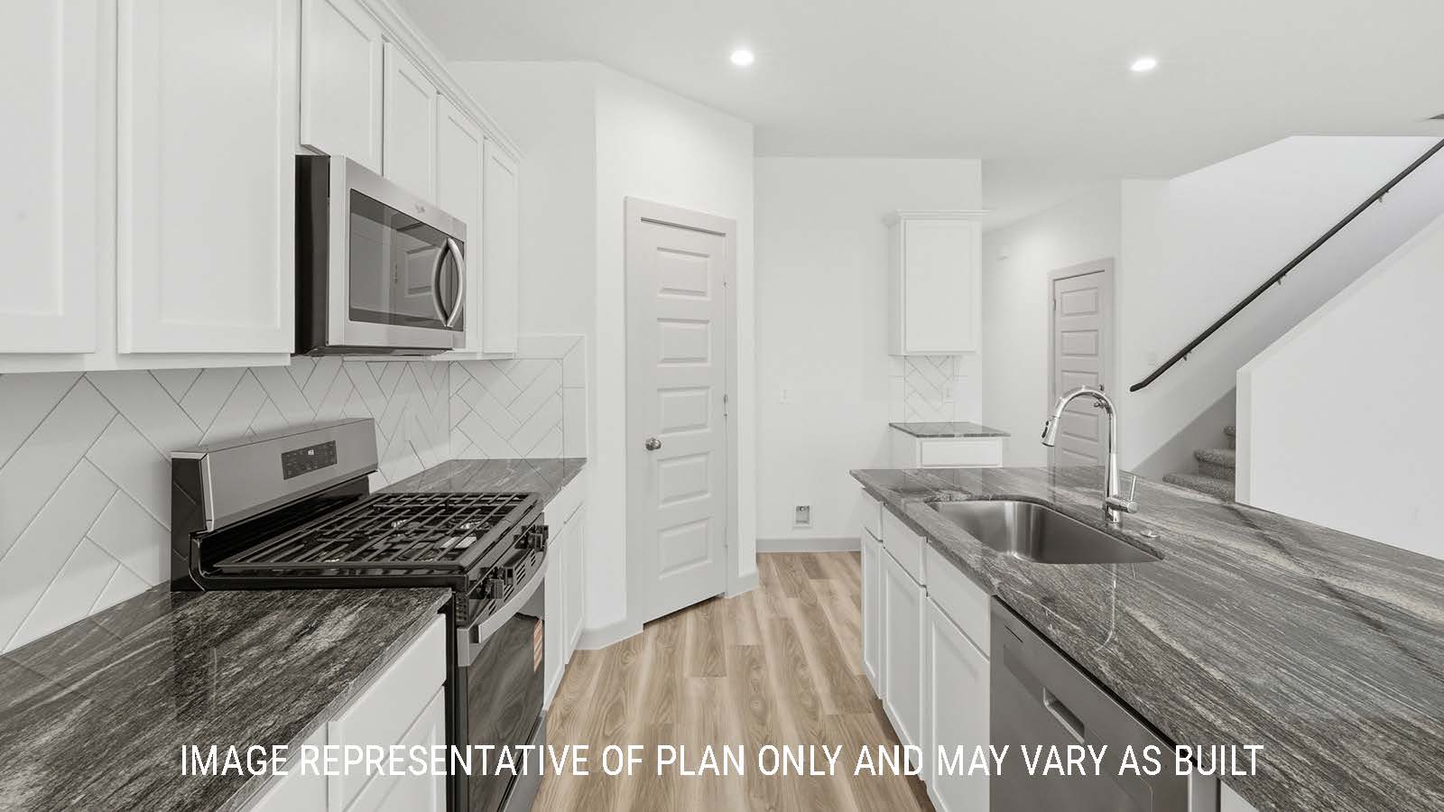Mitchell kitchen with light cabinets and dark granite countertops with view of front entry hallway and stairs.