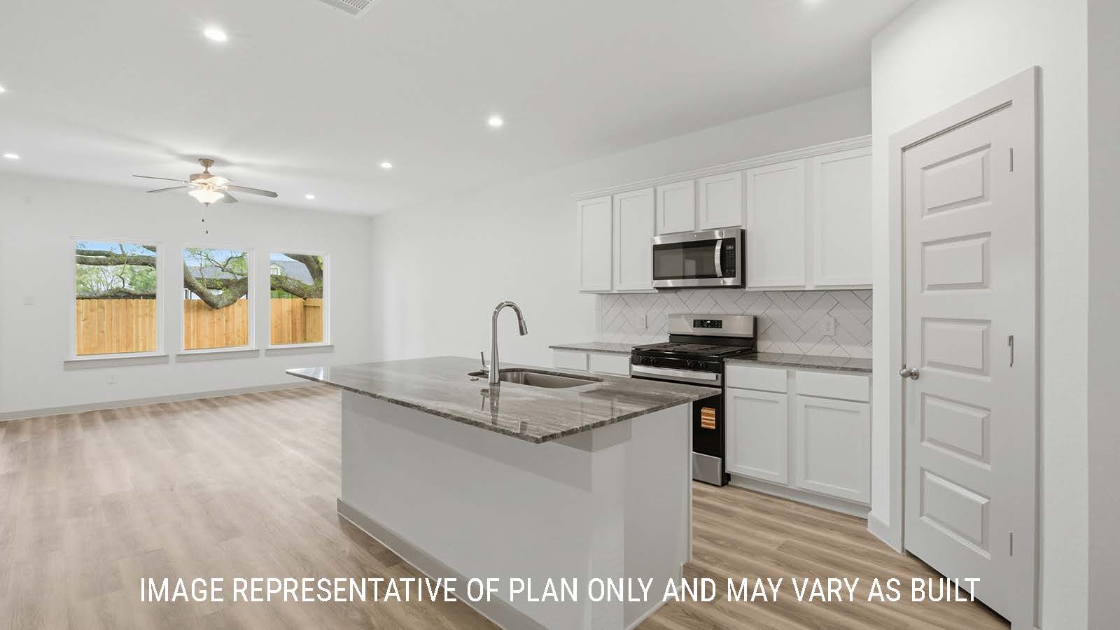 Mitchell kitchen with kitchen island with dark granite countertop and view of open concept living room.