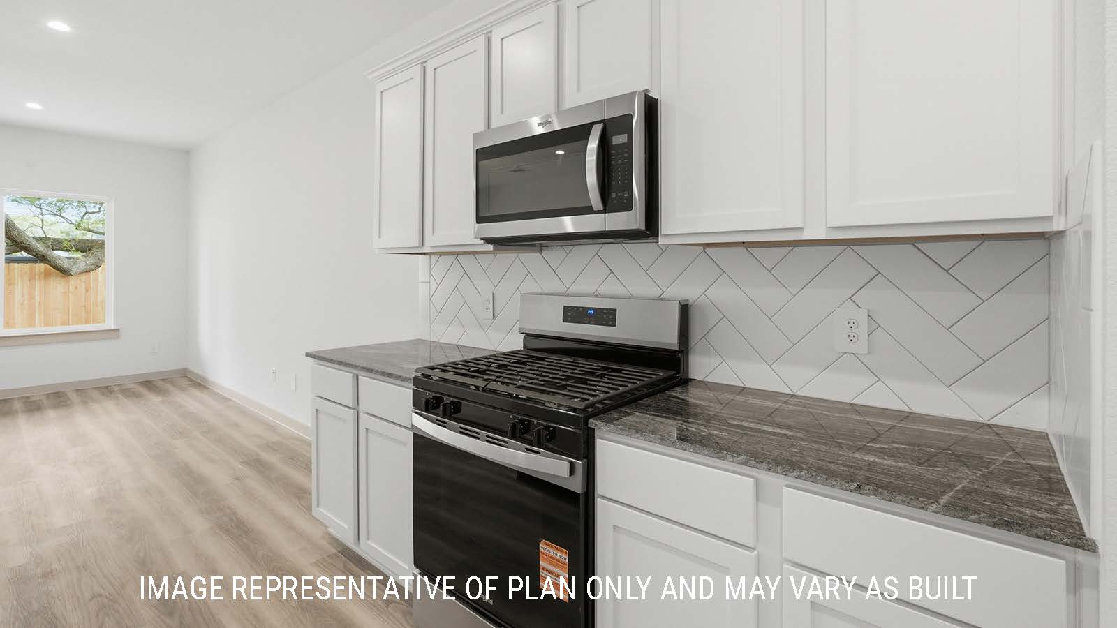 Mitchell kitchen with light cabinets and dark granite countertops with view of open concept living room.