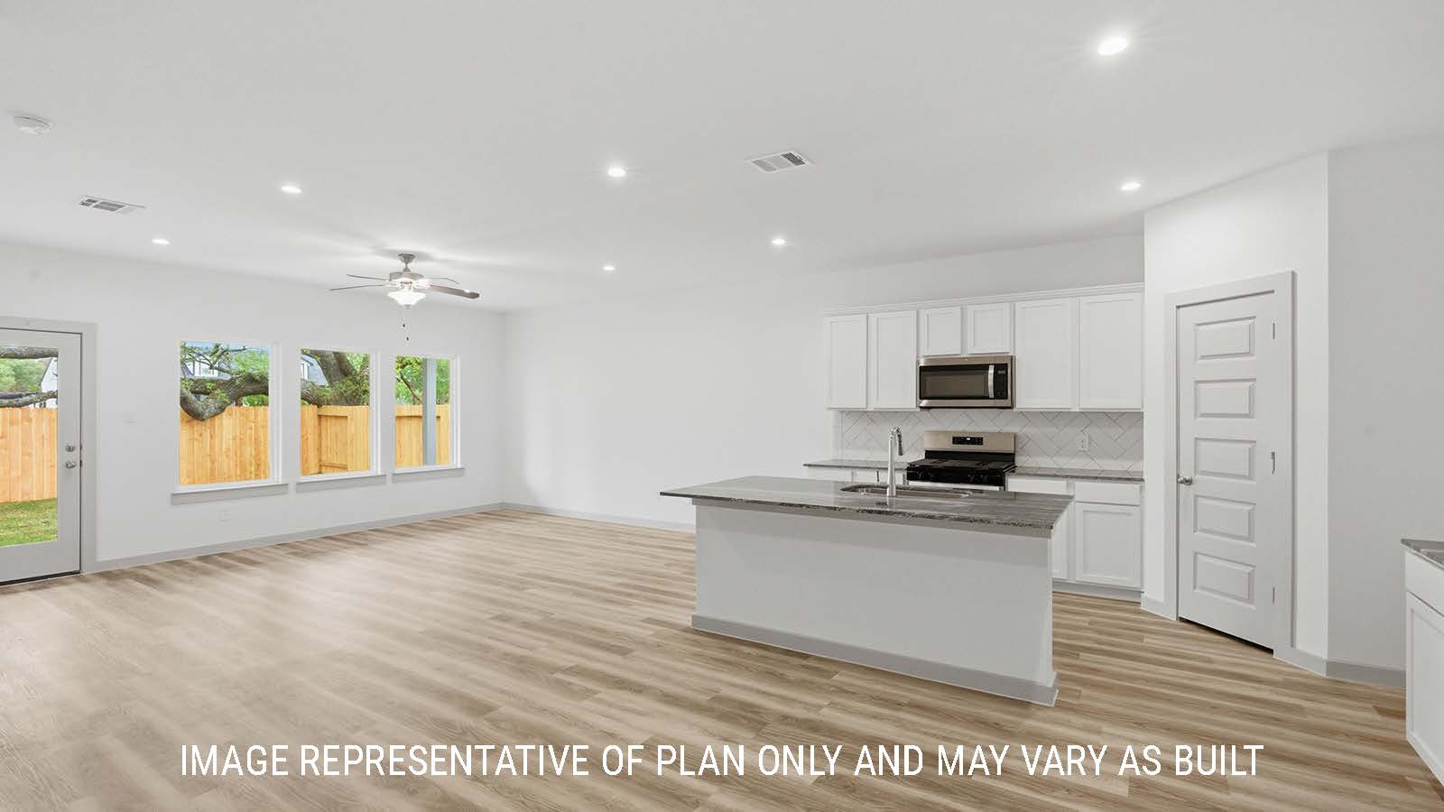 Mitchell kitchen with light cabinets and dark granite countertops with view of open concept living room.