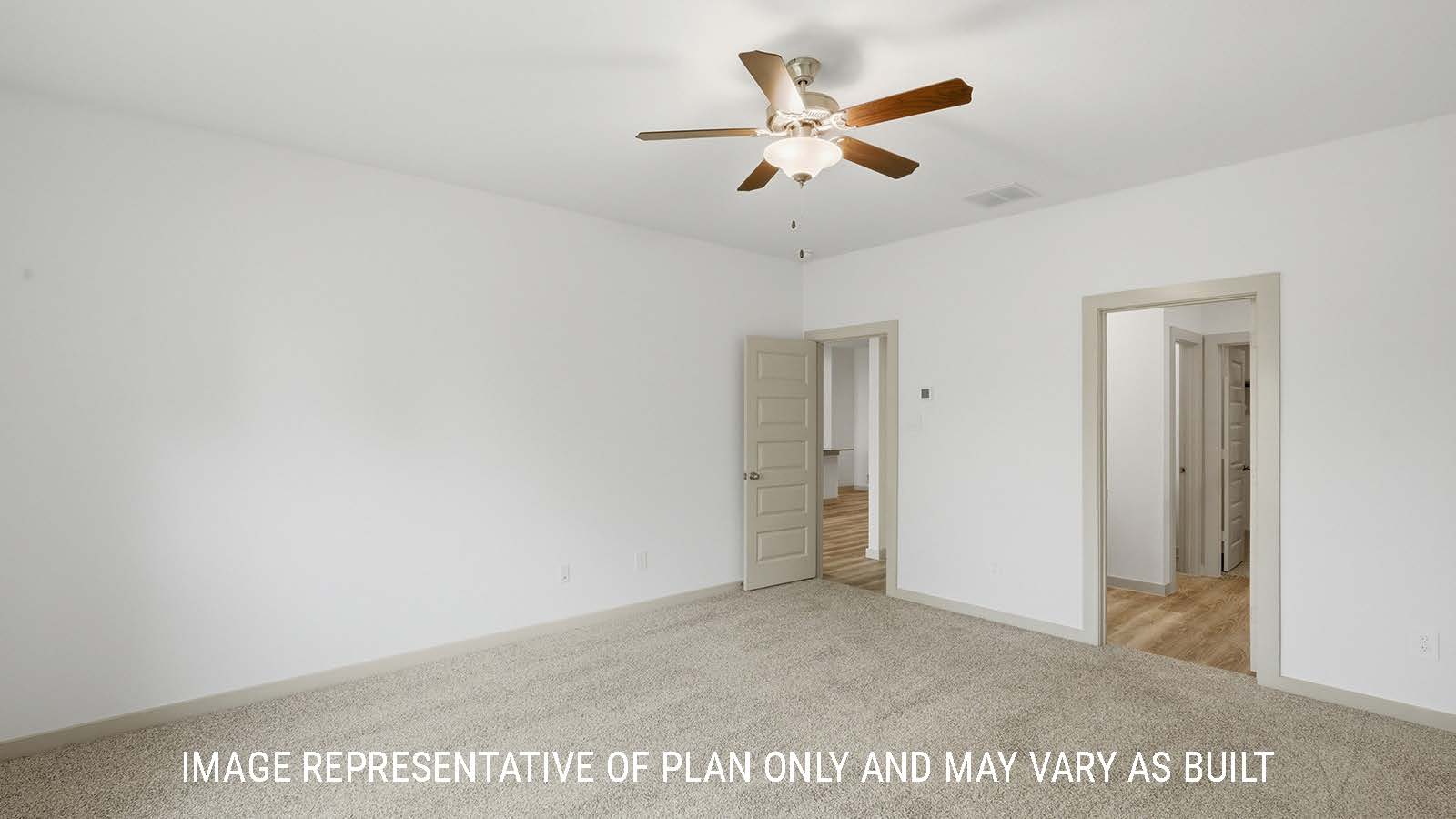 Mitchell primary bedroom with carpeted flooring and view of primary bathroom.