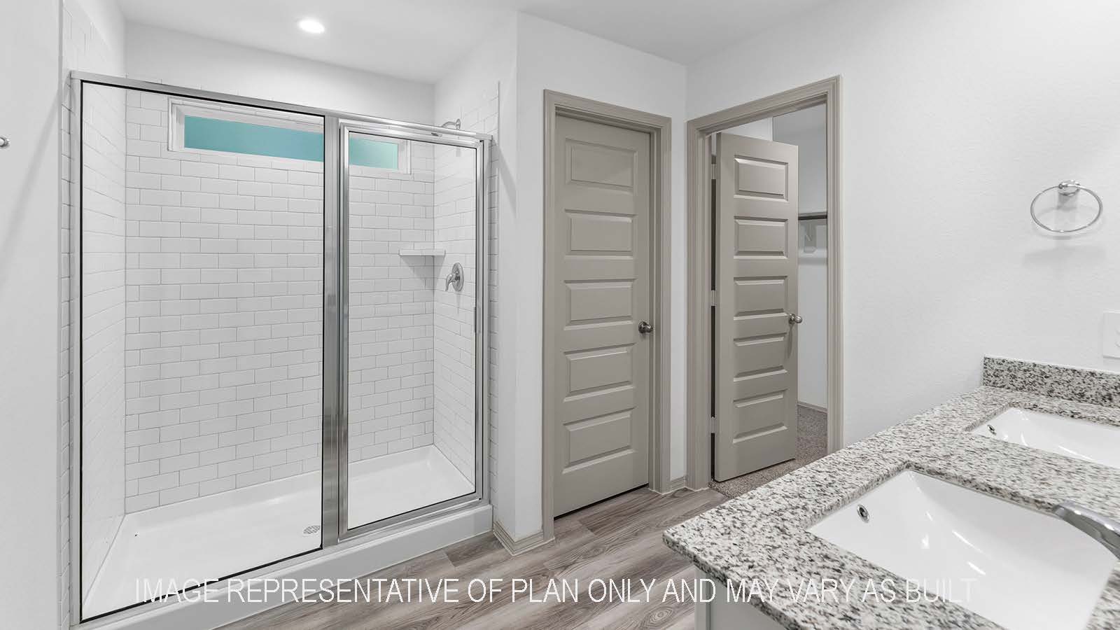 Bellvue primary bathroom with walk-in shower and view of walk-in closet