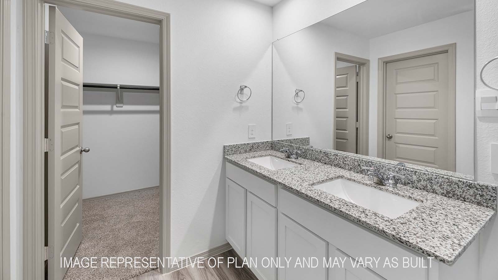 Bellvue primary bathroom with dual vanity sinks with granie countertops.