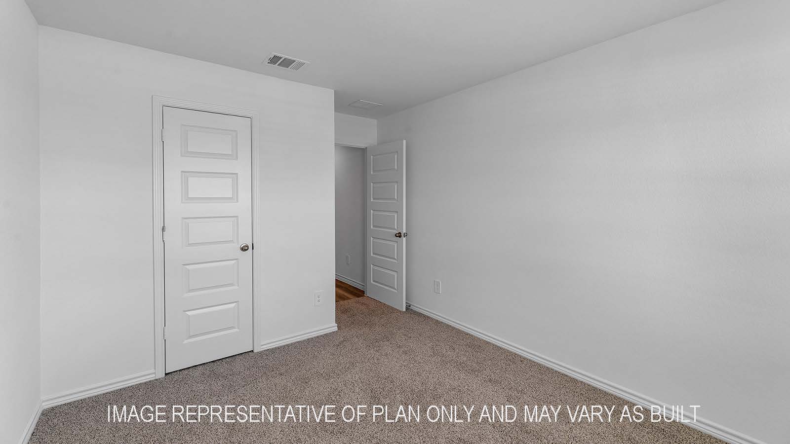 Denton secondary bedroom with carpet flooring and view of hallway.