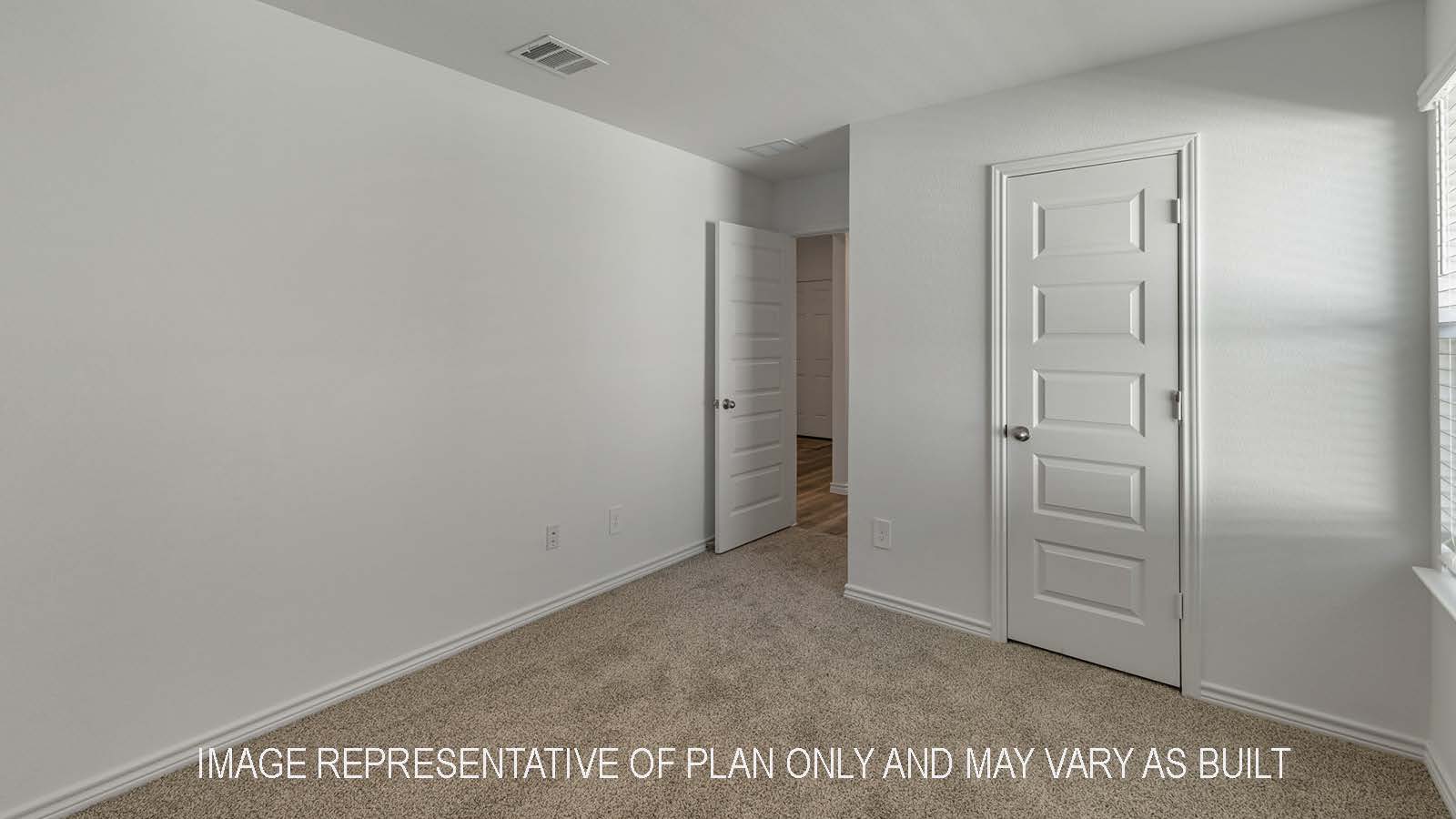 Denton secondary bedroom with carpet flooring and view of hallway.