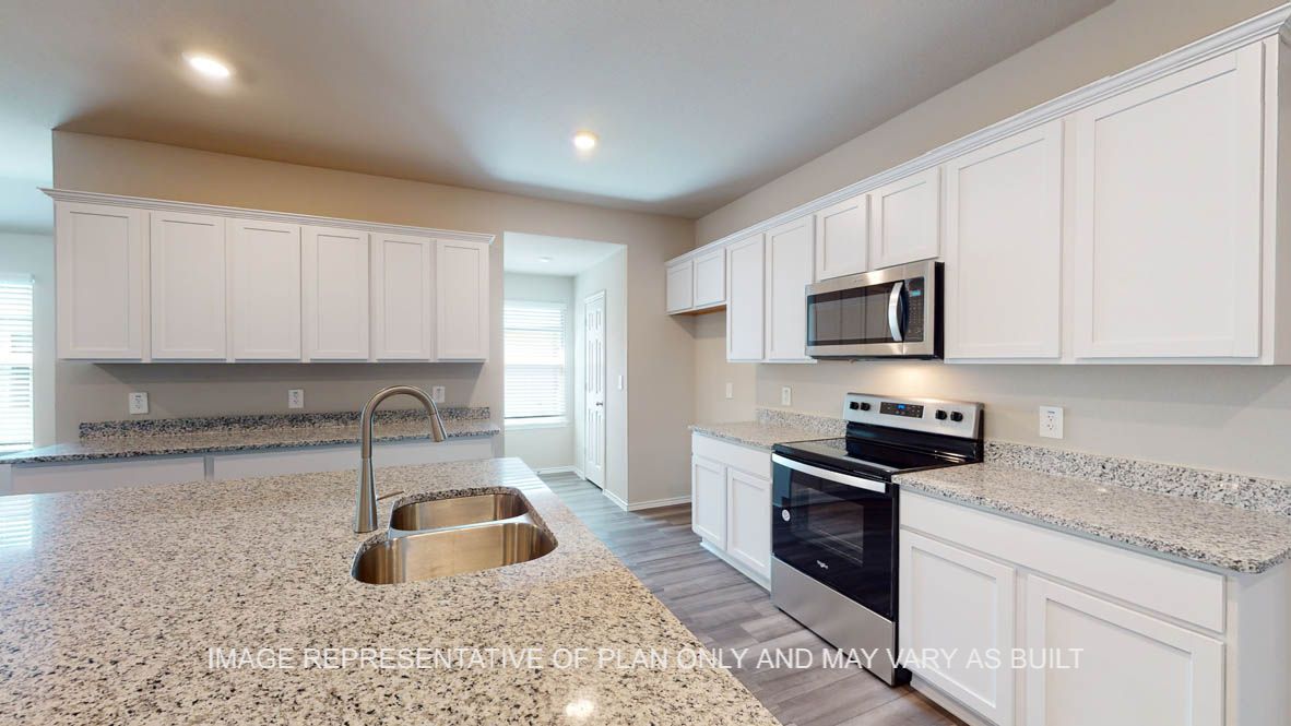 Kingston kitchen with white cabinets and granite countertops with window for natural lighting.