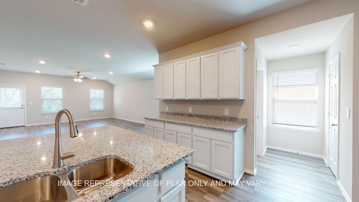 Kingston kitchen with kitchen island with granite countertops and view of open concept dining room and living room.