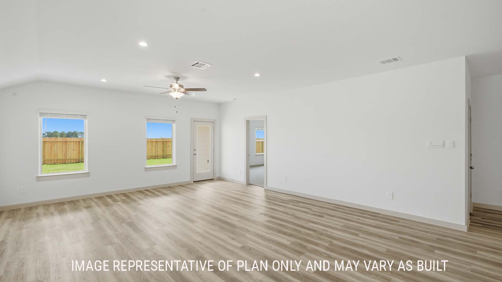Kingston dining room with vinyl plank flooring and view of open concept living room and windows for natural lighting.
