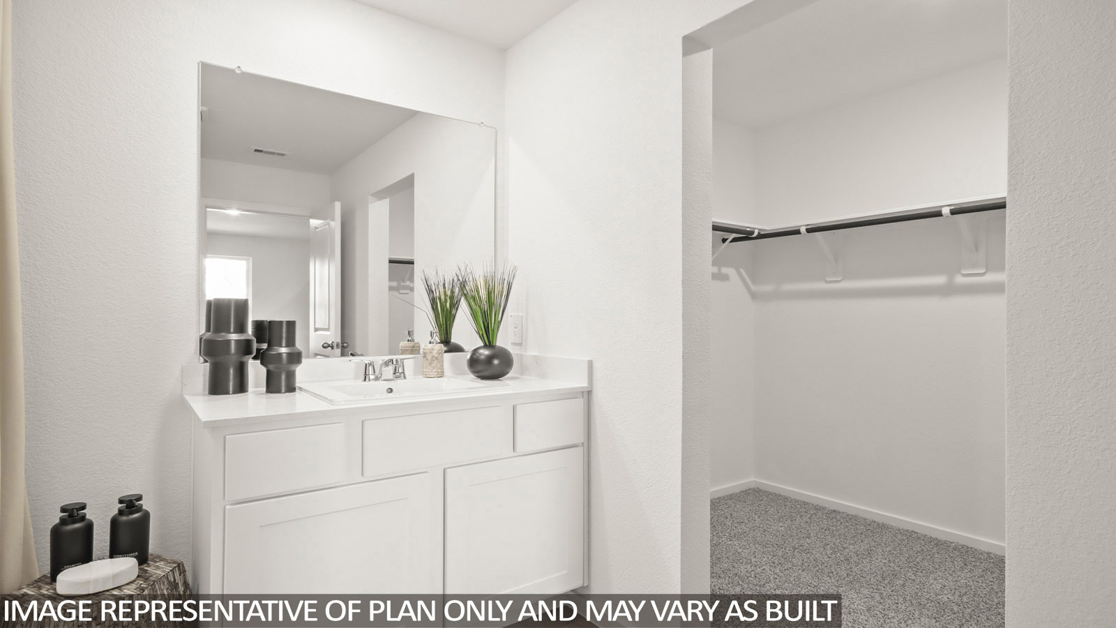 Austin primary bathroom with vanity sink and view of primary walk-in closet.