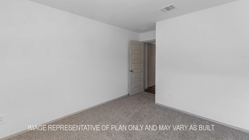 Cali secondary bedroom with carpet flooring and view of the hallway.