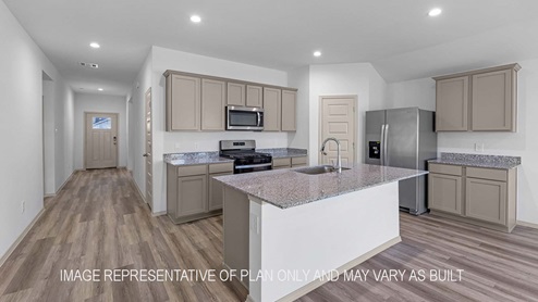 Cali kitchen island with granite countertops and view of entry way.