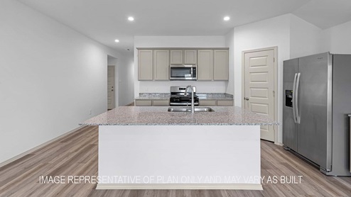 Cali kitchen island with light cabinets and granite countertops.